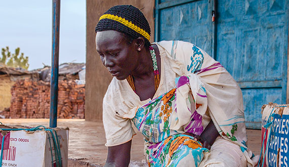 Auf einem Dorfmarkt im Südsudan verkauft eine Frau Obst und Gemüse, um ihren Lebensunterhalt zu verdienen.