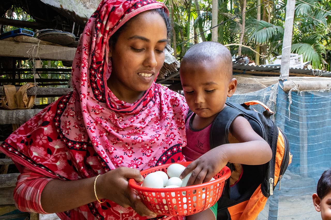 Hosenare Aktar (28 Jahre) mit ihrem zweijährigen Sohn Rakib vor ihrem Haus im Distrikt Bagerhat, Bangladesch.