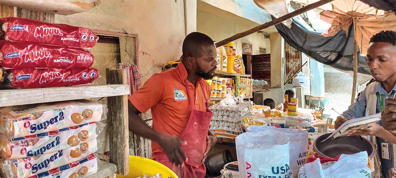 Josef Quetal (27 Jahre) betreibt einen Lebensmittelstand auf dem Ti-Ayiti-Markt in Cité Soleil, Haiti.
