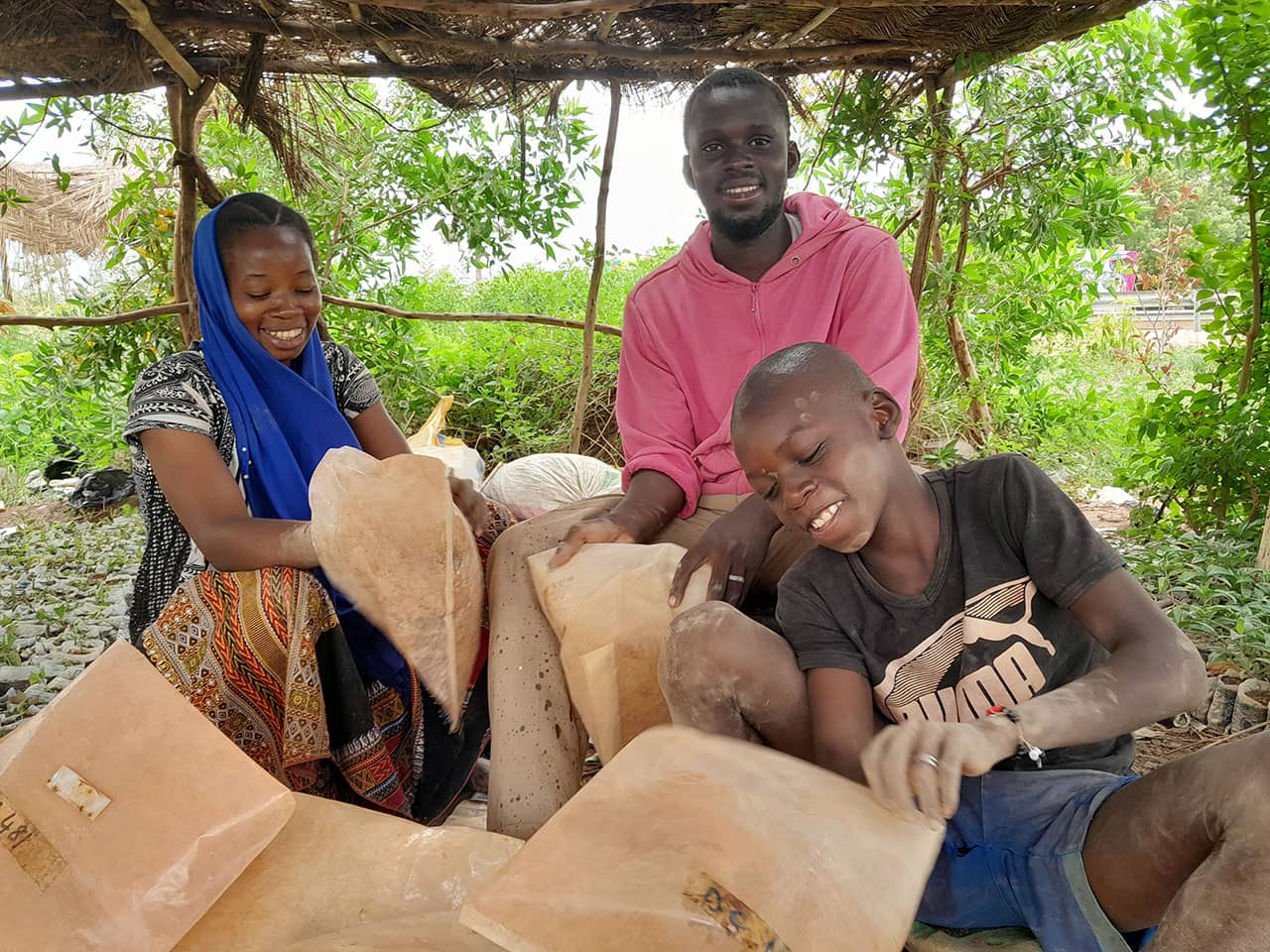 Karim Yalcouye (age 24) and his family sit amid his thriving tree nursery in the Ségou region of Mali.